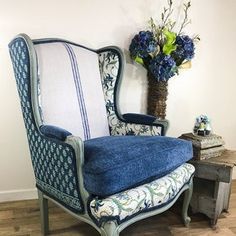 a blue chair sitting next to a vase with flowers