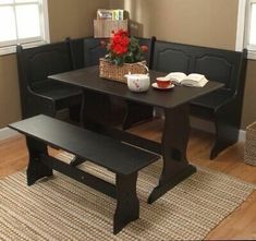 a black table with two benches and a basket full of flowers next to the window