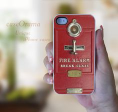 a woman holding up a red fire alarm phone case