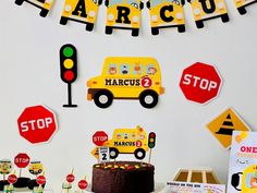 a birthday party with cars, stop signs and paper garlands on the wall above it