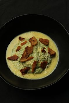 a black bowl filled with food on top of a table