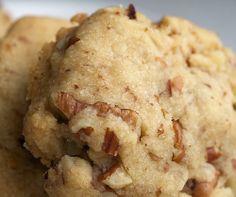 two cookies are stacked on top of each other with pecans in the middle and one is half eaten