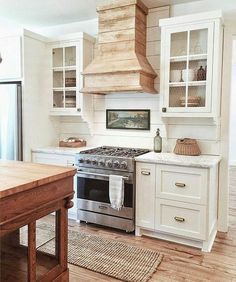 a stove top oven sitting inside of a kitchen next to a wooden dining room table