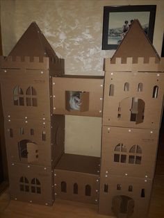 the cardboard castle is made to look like it has been built into the wall with windows and doors