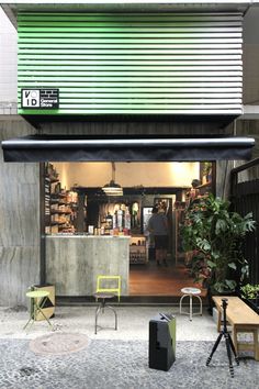 an open store front with green and black awnings