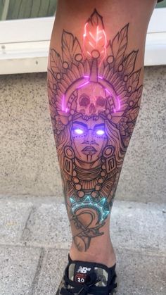 a woman's leg with tattoos and neon lights