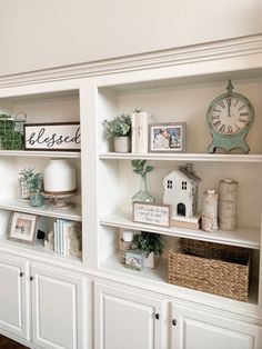 a white bookcase filled with lots of books and other items on top of it