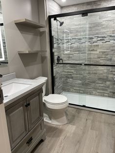 a bathroom with a walk in shower next to a toilet