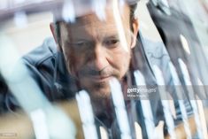 a man looking through the glass at something