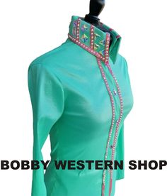 a mannequin wearing a green top with pink and blue beads on it's neck