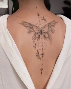 the back of a woman's neck with a butterfly tattoo on it