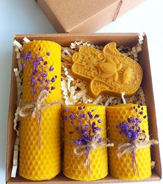 four bees wax candles in a box with lavenders on the inside and an angel cookie