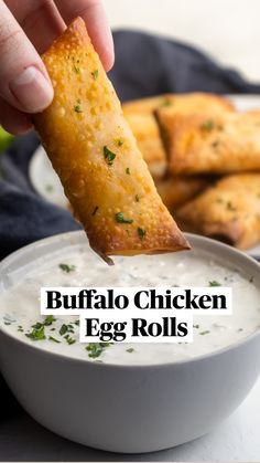 a hand dipping some food into a bowl with ranch dip in it and the words buffalo chicken egg rolls