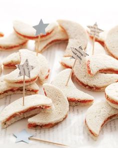 some food that is laying out on a table with toothpicks in the shape of stars and crescents