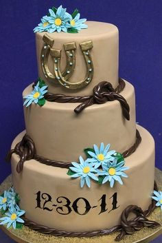 a three tiered cake decorated with daisies and horseshoes