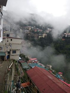 the city is surrounded by fog and low lying clouds