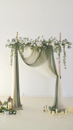 a wedding arch decorated with greenery and candles