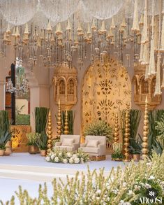 an elaborately decorated stage set up for a wedding ceremony with gold and white decor