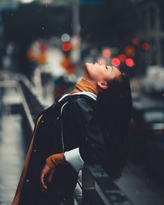 a woman with her eyes closed standing in the rain