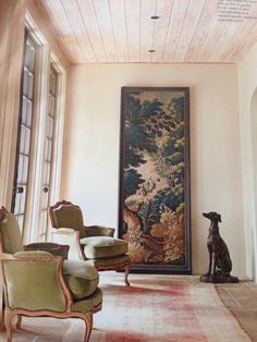 a living room filled with furniture and a painting on the wall