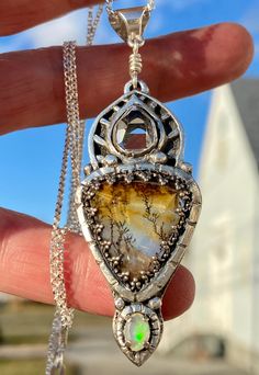 This one of a kind piece is centered around a natural dendritic quartz   (18x20mm) that has been set in fine silver. This beautiful stone loos like a painting, but was made by nature. Accented with a faceted Ethiopian Opal (4x6mm) and a water clear, AA+ grade, Herkimer Diamond quartz crystal we mined in Middleville, NY (7x12 mm). The Opal has been faceted and has multi color flash (hard to capture in most of the photos). The Herkimer diamond was mined in Middleville, NY. This very fine natural d Artisan Amber Jewelry With Natural Inclusions, Nature-inspired Moss Agate Jewelry With Natural Inclusions, Nature-inspired Jewelry For Healing With Natural Inclusions, Dendritic Quartz, Quartz Crystal Pendant, Magical Jewelry, Diamond Quartz, Art Pendant, Herkimer Diamond