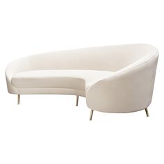 a white curved couch sitting on top of a wooden table