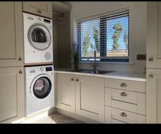 a washer and dryer sitting in a kitchen next to a window with blinds