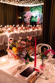 the table is set with flowers, candles and place settings for an elegant wedding reception