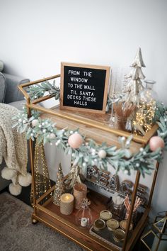 a christmas display in a living room filled with ornaments and decorations, including a chalkboard sign that says from the window to the wall doesn't