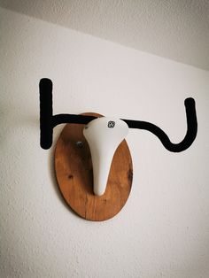 a wall mounted hair dryer sitting on top of a wooden board next to a white wall