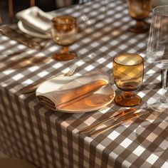 the table is set with glasses, silverware and napkins for two people to eat