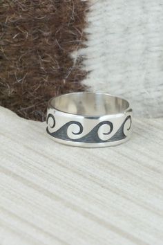 This sterling silver ring was made by Hopi silversmith Timothy Mowa.Size: 12.25Length: 3/8"Free shipping on all orders! We ship with USPS and always include tracking. All orders ship within a day of payment.Returns are accepted up to 30 days after you receive your order. Just send us a message. Our shop offers cash back or store credit. The item must be returned in new condition. Artisan Sterling Silver Wide Band Ring, Artisan Sterling Silver Engraved Hallmarked Ring, Artisan Sterling Silver Rings In White Gold, Artisan White Gold Rings In Sterling Silver, Artisan White Gold Sterling Silver Rings, Hand Forged Sterling Silver Engraved Ring, Symbolic Hand Forged Sterling Silver Rings, Sterling Silver Concave Ring Stamped 925, Native American Jewelry