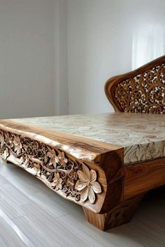 a wooden bed with intricate carvings on the headboard and foot board, in a white room