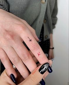 two people with matching tattoos on their fingers