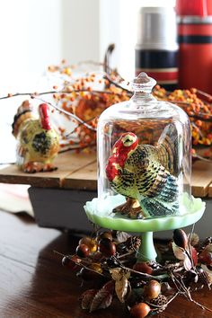 two turkey figurines under a glass clochet