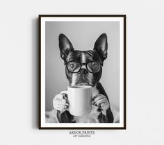 a black and white photo of a dog wearing glasses drinking from a coffee cup