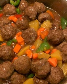 meatballs, carrots and peppers are in a pot with broth on the side