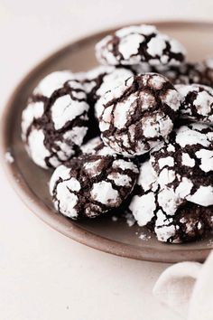 chocolate crinkle cookies on a plate with white powdered sugar in the middle