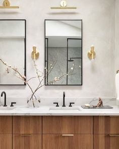 a bathroom with two sinks and mirrors above them