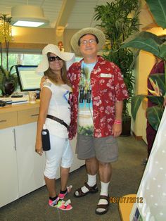 a man and woman standing next to each other in front of a counter with plants