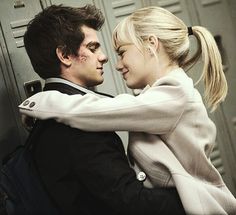 a man and woman hugging each other in front of lockers