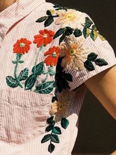 a woman wearing a shirt with flowers on it