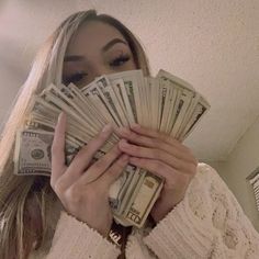 a woman covering her face with money