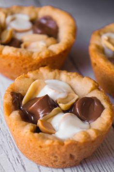 three mini desserts with chocolate and marshmallows in them on a table