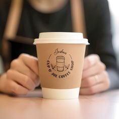 a person sitting at a table with a coffee cup