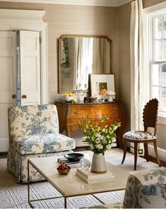 a living room filled with furniture and a mirror on top of a table in front of a window