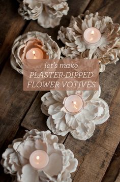 some white flowers and candles are on a wooden table with the words merken above them