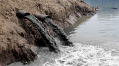 the water is running out of the pipe into the river bed and onto the side of the hill