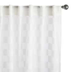 a white shower curtain hanging on the side of a wall