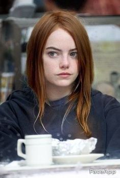 a woman with red hair sitting at a table